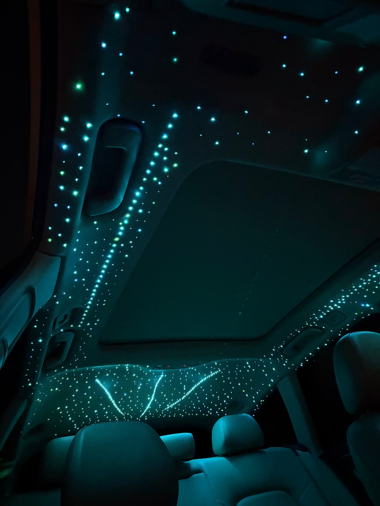 Teal starlight headliner around a sunroof
